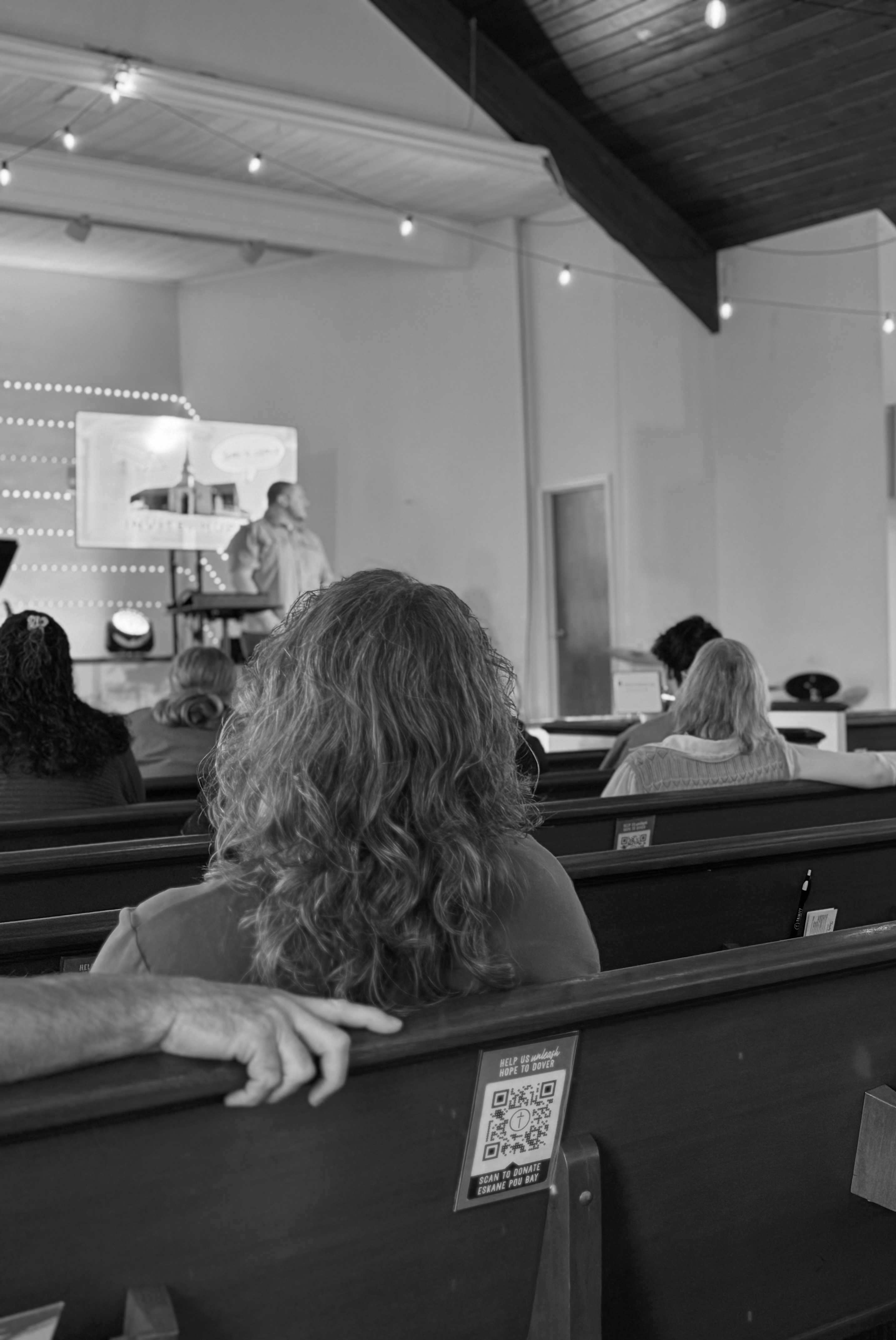 Woman sitting in Pew listening to Pastor preach