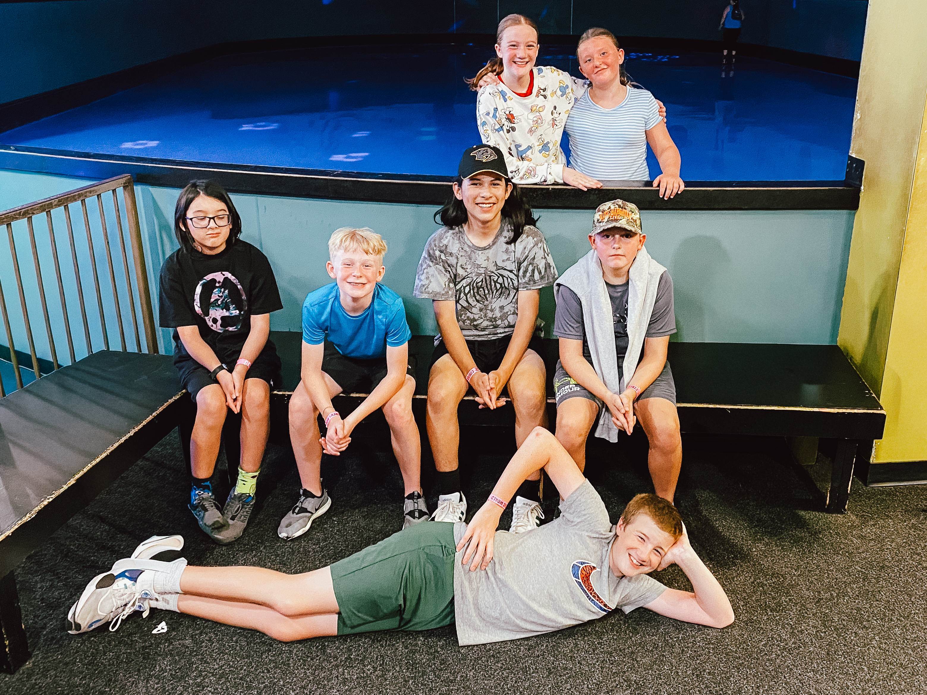 Seven Oasis Students posing together during a group outing, with one student reclining playfully in front.