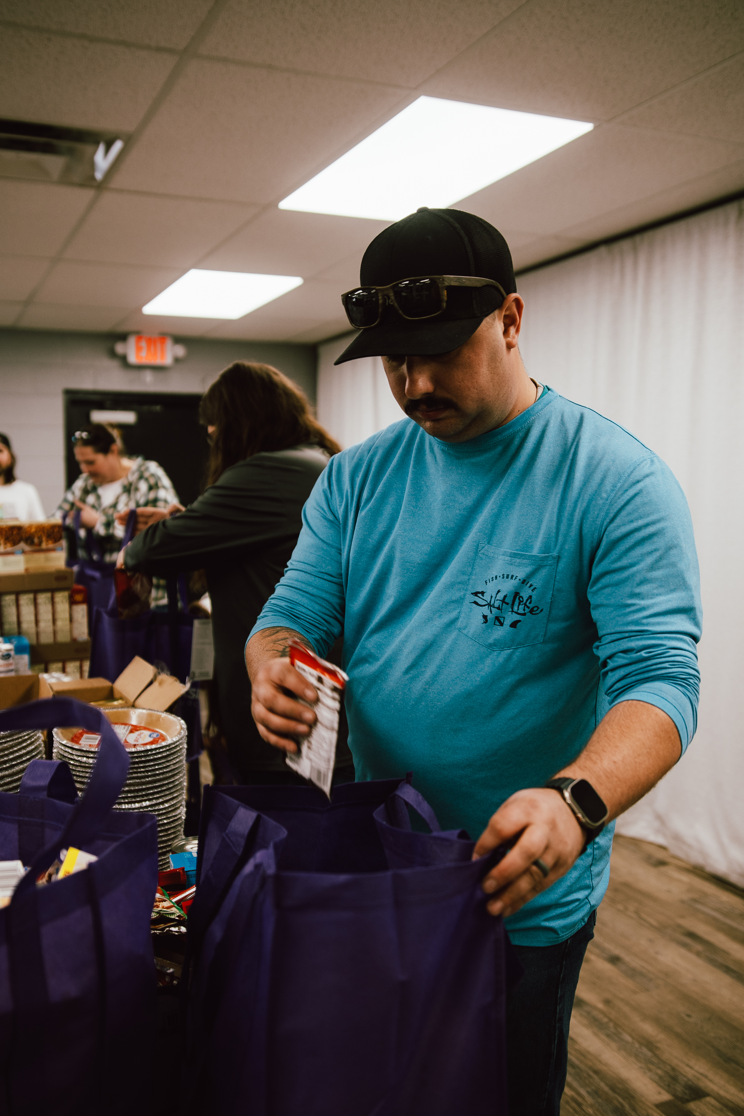 Volunteer packing a Thanksgiving meal bag for Oasis Church’s Give a Meal event.