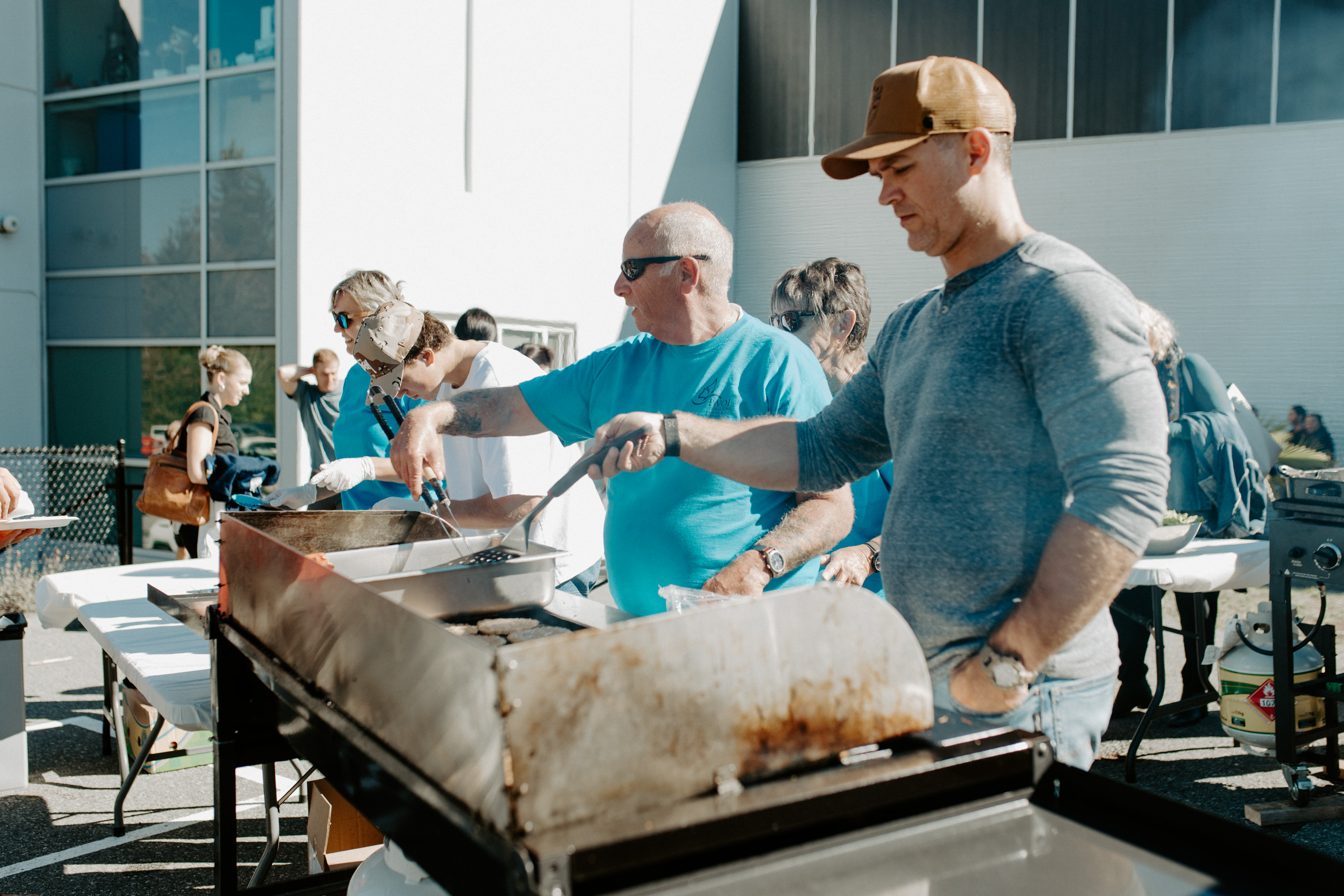 Men barbecuing burgers on a grill