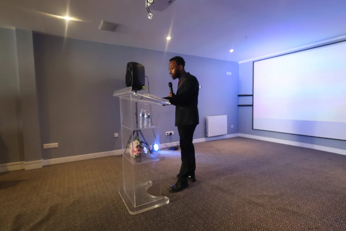 A speaker delivering a message at a lectern during a church gathering.