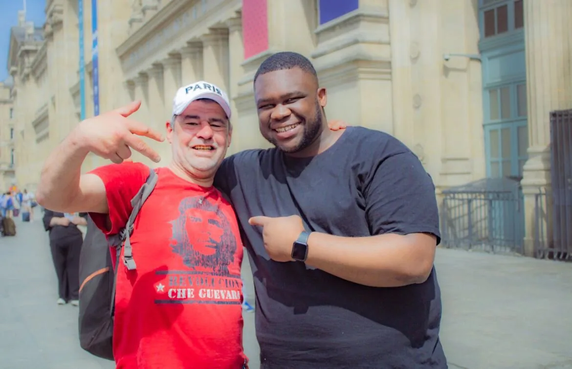 Two men smiling together in a Paris street.