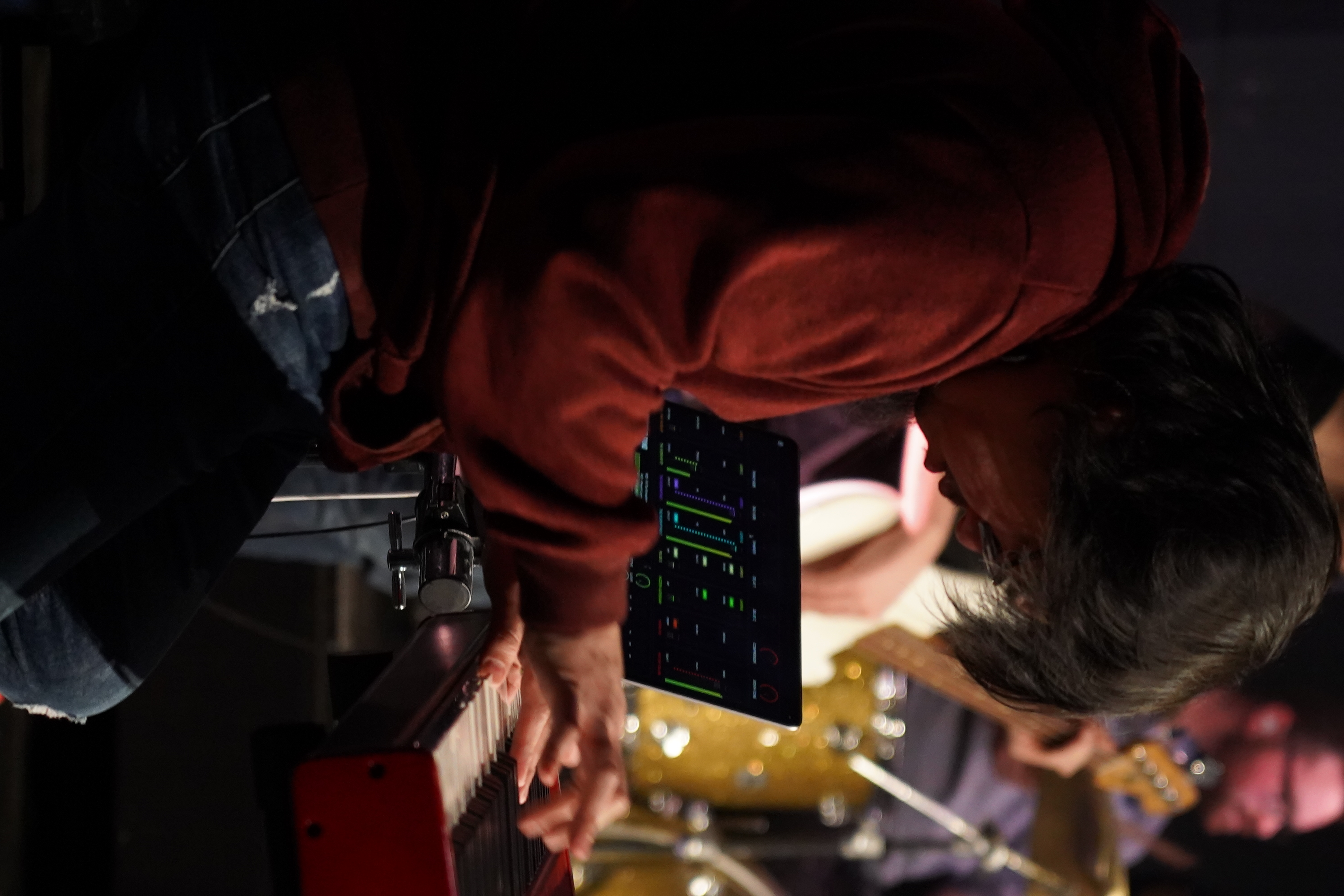 A keyboard player performing during worship at Faith Summit St, focused on playing in a dimly lit stage setting.