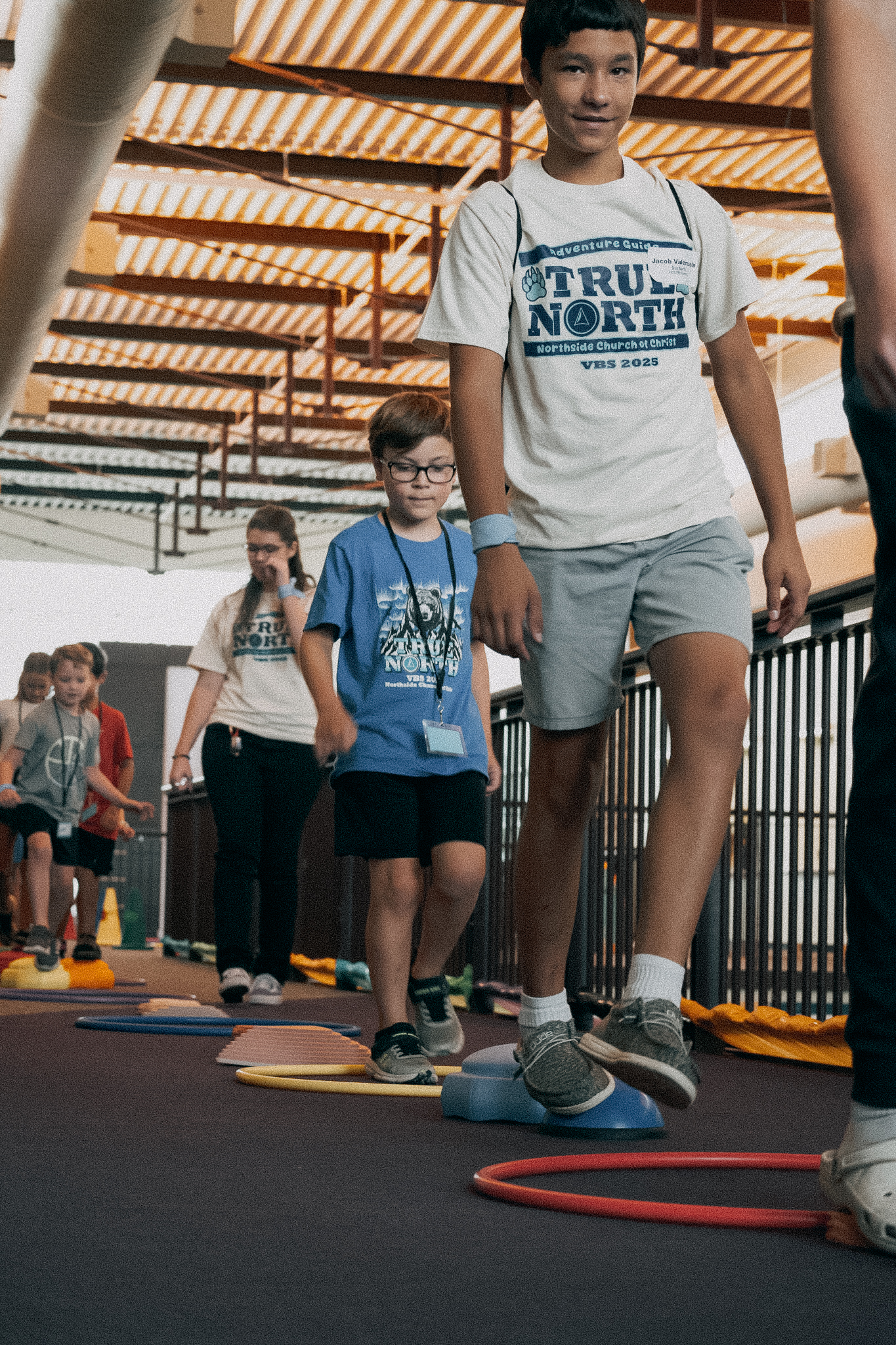 Children lined up to play a game with hula hoops.