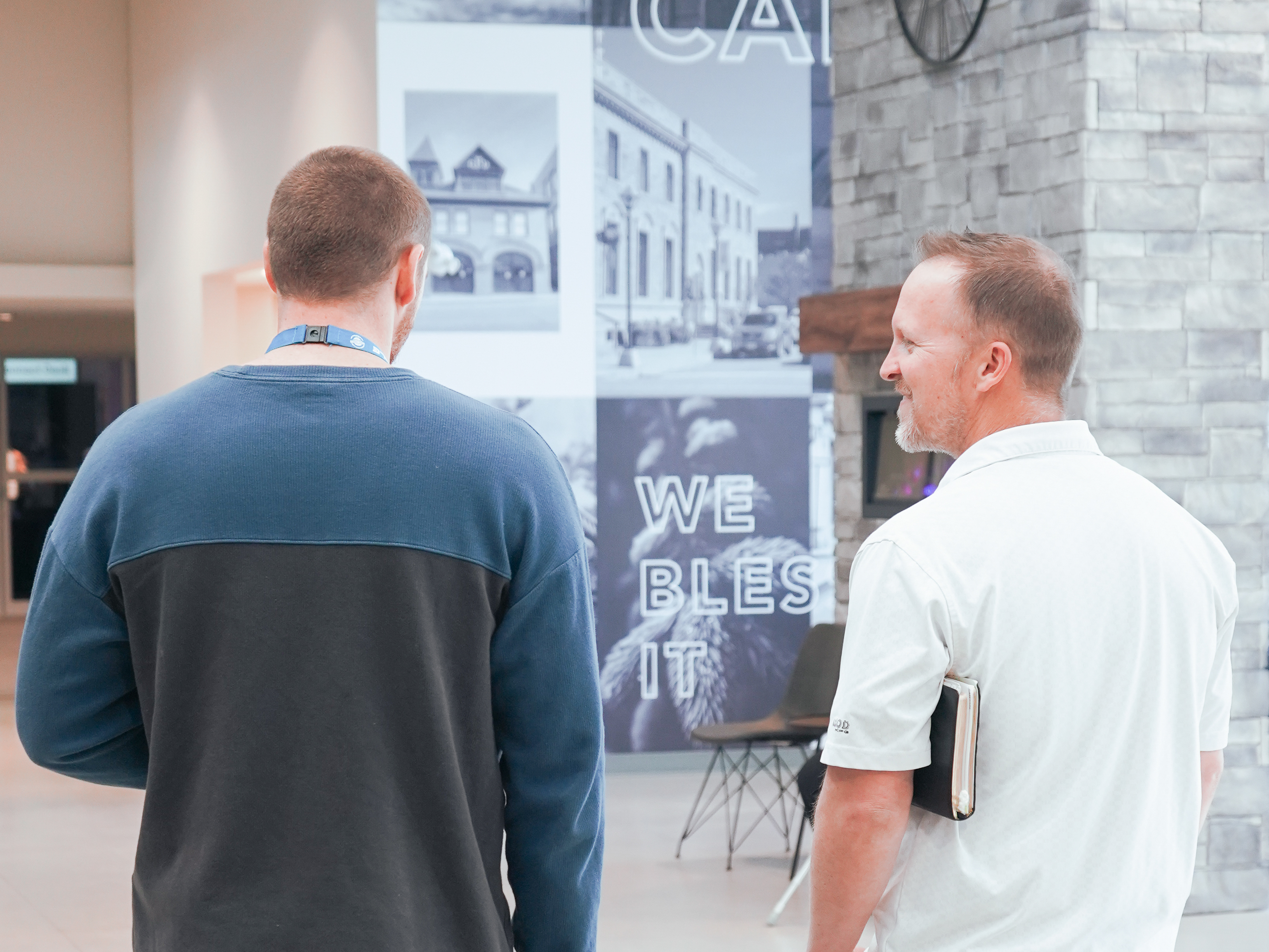 Two men chatting and smiling in the Temple Baptist Church lobby.