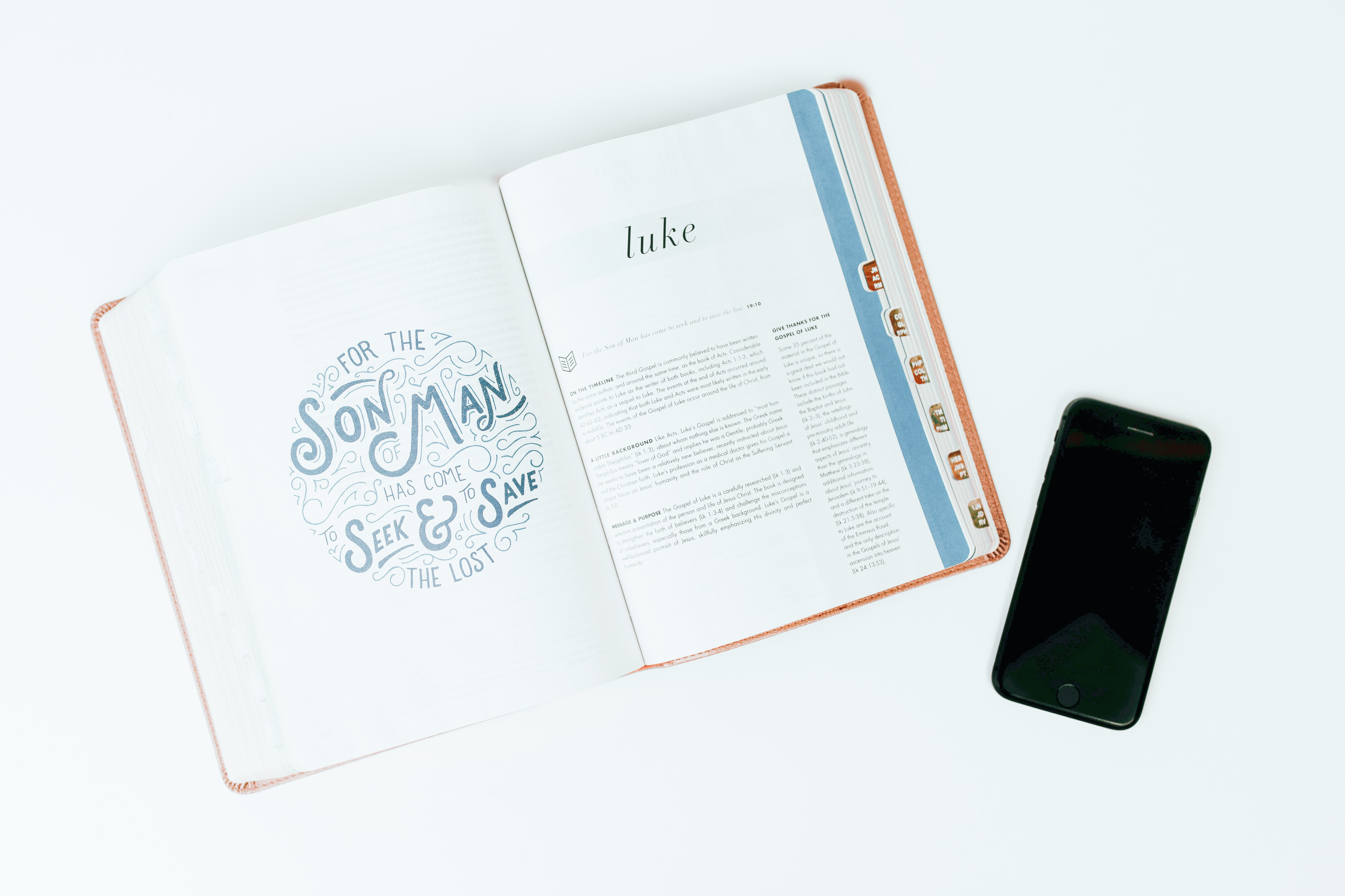 An open Bible beside a cell phone