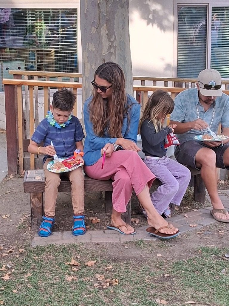 Parent ans childrens eating under a tree