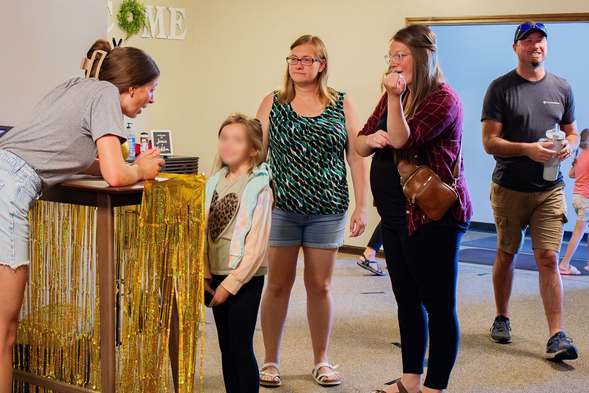People gathering in the welcome area at Shelby Alliance Church; the child’s face is blurred for privacy.