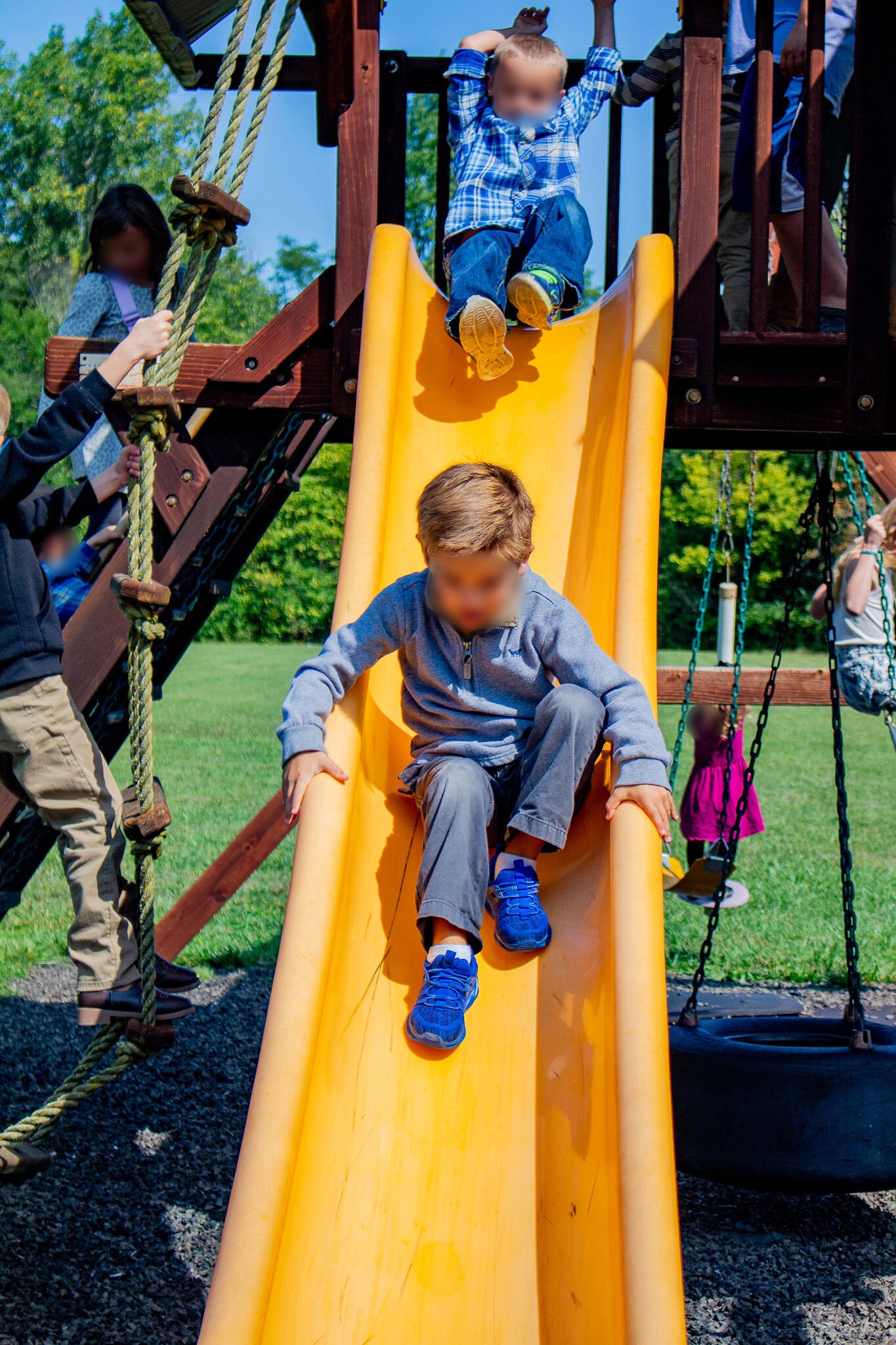 Children playing on the playground at Shelby Alliance Church; their faces are blurred for privacy.