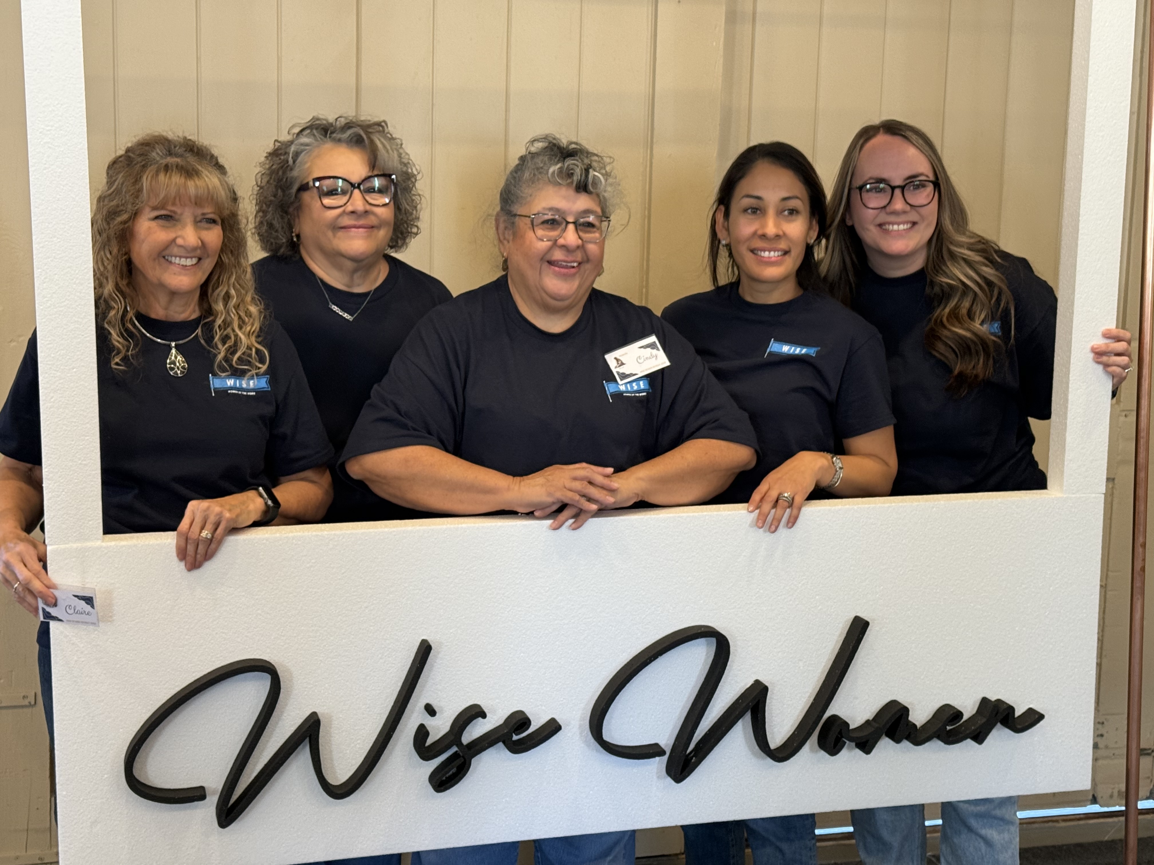 Women's Ministry leaders holding banner saying Wise Women