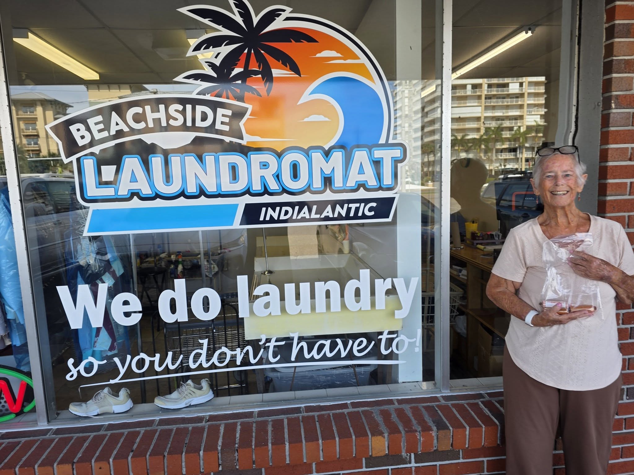 Wendy in front of a Laundromat sign with a bag of quarters