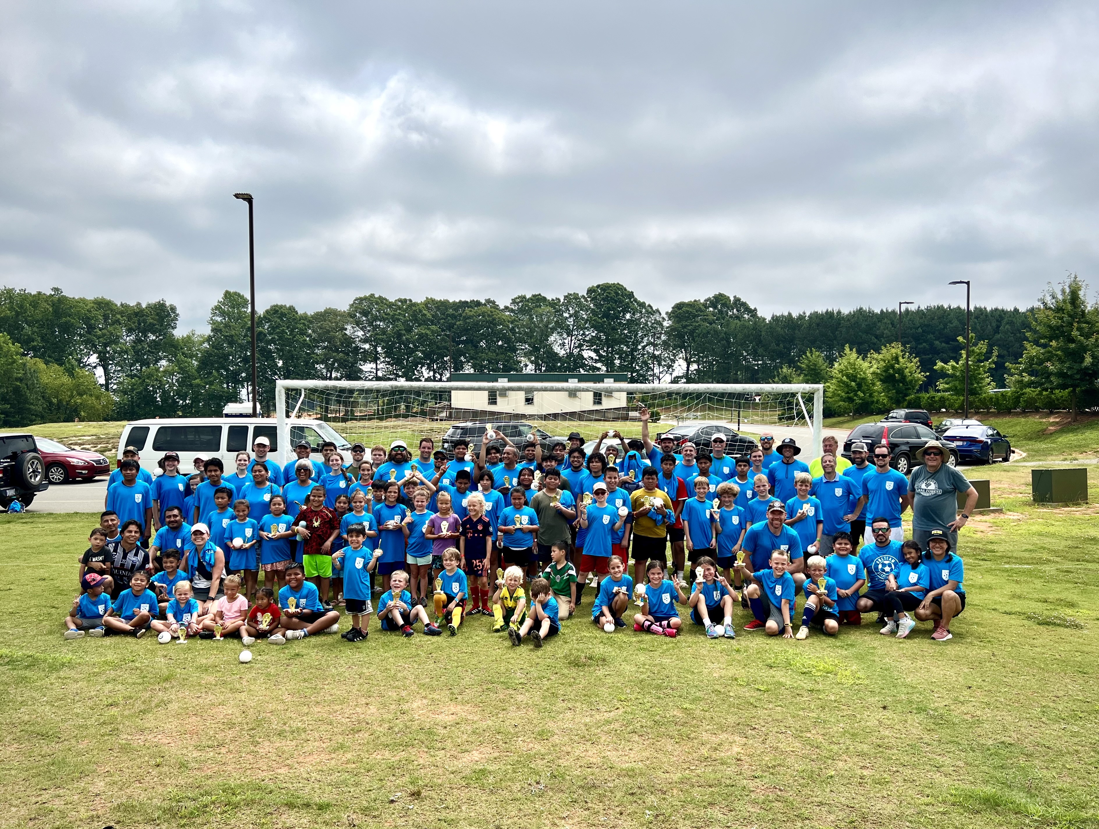 A mechanic lays on the ground beneath a car to change its oil.